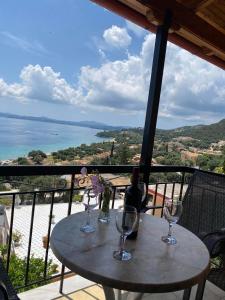 uma mesa com copos de vinho sentados numa varanda em Emilios see view Apartment em Barbati