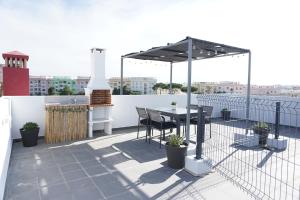 a patio with a table and a grill on a roof at Casa Gaio's in Parchal