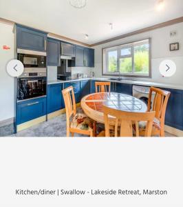 a kitchen with blue cabinets and a table and chairs at Swallow lodge in Lincolnshire