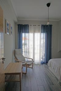 1 dormitorio con silla, 1 cama y 1 mesa en Casa Gaio's en Parchal