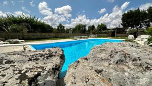 a swimming pool with two large rocks next to it at La Chiesura in Galugnano