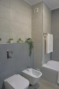La salle de bains est pourvue de toilettes, d'une baignoire et d'un lavabo. dans l'établissement Casa Gaio's, à Parchal