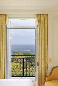 a bedroom with a large window with a view of the ocean at Grand-Hôtel du Cap-Ferrat, A Four Seasons Hotel in Saint-Jean-Cap-Ferrat
