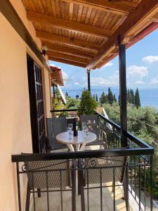 a patio with a table and chairs on a balcony at Emilios see view Apartment in Barbati