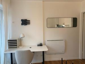 a white desk with a mirror and a chair at Studio Tivoli la Tour in Dijon