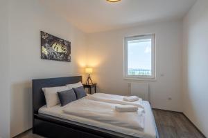 1 dormitorio con 1 cama grande y ventana en LelleResort BLTN Apartmanok By BLTN, en Balatonlelle