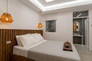 a bedroom with a large bed with a wooden headboard at Oikia Suites Mykonos in Mýkonos City