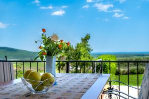 un bol de fruta en una mesa con un jarrón de flores en Villa Poemia, en Rogachevo