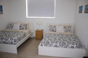 a bedroom with two beds and a lamp on a night stand at Oceanfront Condo - Ocean Views, Pool, Gym Hollywood Beach in Hollywood