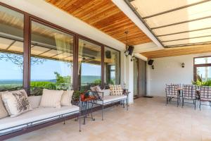 Una sala de estar con un sofá y sillas y ventanas. en Villa Poemia, en Rogachevo