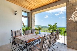 Un comedor con mesa y sillas en un balcón. en Villa Poemia, en Rogachevo