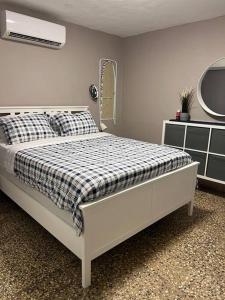 1 dormitorio blanco con 1 cama con colchón a cuadros en Villa Orquidea 1, en Humacao
