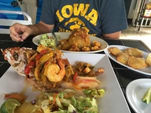 a man sitting at a table with plates of food at Villa Orquidea 1 in Humacao