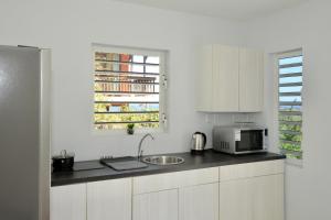 cocina blanca con fregadero y microondas en Beach House,Villa Santirome/Free Wifi,Parking, en Westpunt