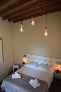 een slaapkamer met een groot wit bed met verlichting bij Antica Dimora Santa Sofia in Nardò