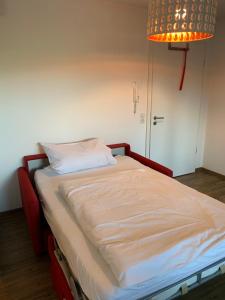 a bed in a room with a light and a lamp at Ferienwohnungen Gergert Nr4 in Löwenstein