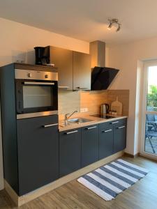 una cocina con fregadero y estufa en Ferienwohnungen Gergert Nr4, en Löwenstein