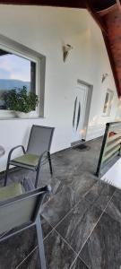 sala de estar con 2 sillas y ventana en Apartman Karolina, en Rudanovac