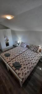 1 dormitorio con 1 cama con colcha de flores en Apartman Karolina, en Rudanovac