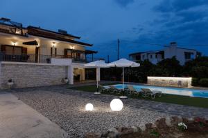 a villa with a swimming pool at night at Villa Ero in Argos