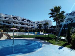 a swimming pool in front of a large apartment building at El Islote de Terreros in San Juan de los Terreros
