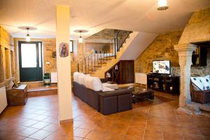 ein Wohnzimmer mit einem Sofa und einer Treppe in der Unterkunft Casa A Canteira in Vimianzo