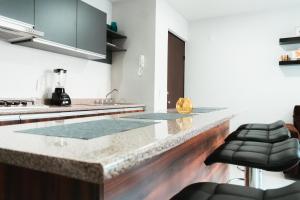 a kitchen with a marble counter top in a room at Hermoso y Comfortable Departamento 15 min del Aeropuerto in Guadalajara +19 photos