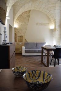 een woonkamer met een bank en een tafel bij Antica Dimora Santa Sofia in Nardò