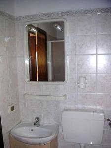 een badkamer met een wastafel en een spiegel bij Casa Belvedere -tranquillità tra bosco e ulivi- in Riparbella