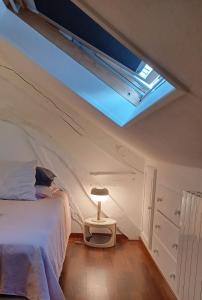 a bedroom with a bed and a skylight at Lin et l'hôte in Préaux