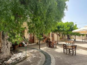 a patio with tables and chairs and trees at Almond Grove Luxury Villa Wprivate Pool in Simou