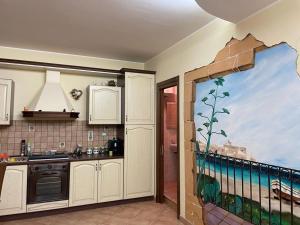 una cucina con un dipinto sul muro di Don Concetto a Marzamemi