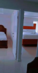 een slaapkamer met 2 bedden en een deur naar een kamer bij Impeccable 2-BR Apartment-Ornella Villa at Bayfront Villa in Portmore