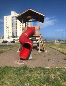 a playground with a red slide in a park at Impeccable 2-BR Apartment-Ornella Villa at Bayfront Villa in Portmore