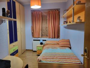 a small bedroom with a bed and a table at Casa Víctor in Ciudad-Rodrigo