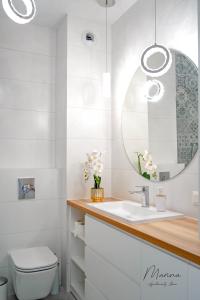 a bathroom with a sink and a mirror at Marina Apartament 11 Iława - z prywatnym miejscem parkingowym w podziemnym garażu in Iława