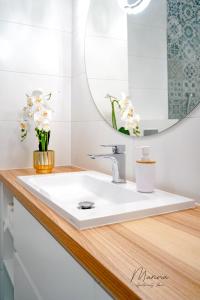 a bathroom with a white sink and a mirror at Marina Apartament 11 Iława - z prywatnym miejscem parkingowym w podziemnym garażu in Iława