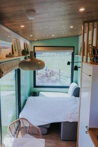 ein Schlafzimmer in einem winzigen Haus mit einem Bett und einem Fenster in der Unterkunft Tiny Transylvania, Rising high above Cluj-Napoca in Cluj-Napoca