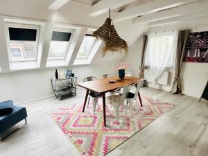 a dining room with a table and chairs on a rug at Ostseewelle, Parkplatz in Kiel +6 photos