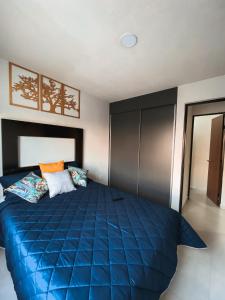 a bedroom with a blue bed in a room at Hermoso y Comfortable Departamento 15 min del Aeropuerto in Guadalajara