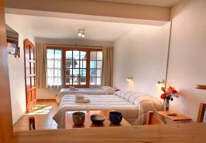 a bedroom with a large bed and a living room at LA PONDEROSA Apart Hotel in San Carlos de Bariloche