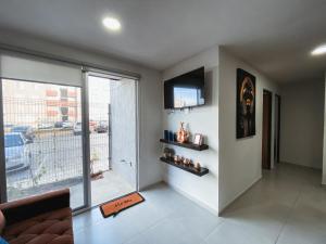 a living room with a couch and a television on a wall at Hermoso y Comfortable Departamento 15 min del Aeropuerto in Guadalajara