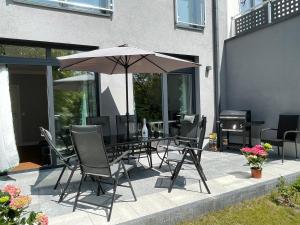 - une table et des chaises avec un parasol sur la terrasse dans l'établissement Luxuriöses Ferienhaus nähe Kattowitz, à Tarnowskie Góry