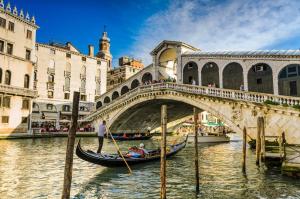 een gondel in het water onder een brug bij Rifugio alle Vele in Venetië