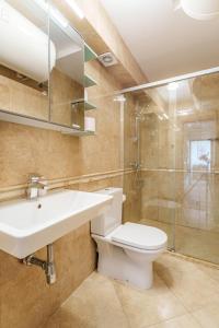 y baño con aseo, lavabo y ducha. en Apartment Poemia, complex Carpe Diem, private pool and free parking en Balchik