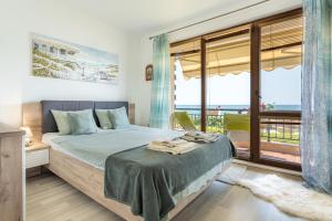 1 dormitorio con 1 cama y vistas al océano en Apartment Poemia, complex Carpe Diem, private pool and free parking, en Balchik