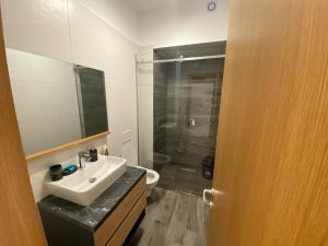 La salle de bains est pourvue d'un lavabo et d'une douche. dans l'établissement Private Villa at Olea Luxury Resort, à Dhërmi