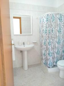 W łazience znajduje się umywalka, toaleta i lustro. w obiekcie Rosso di Sera Loft w mieście Menfi