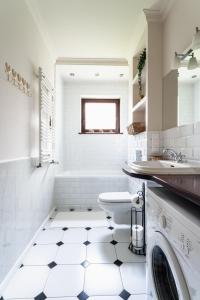 a white bathroom with a toilet and a sink at Apartamenty Niebanalne - Blisko Krupówek in Zakopane