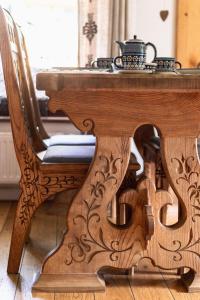 drewniany stół i krzesło z podwieczorkiem na górze w obiekcie Apartamenty Niebanalne - Blisko Krupówek w Zakopanem